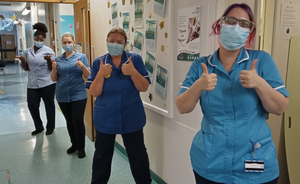 Four nurses doing thumbs up