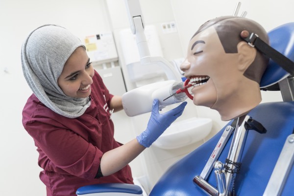 Dental nurse practicing on a dummy