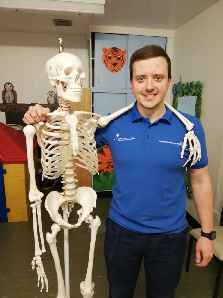Staff member posing with skeleton model.
