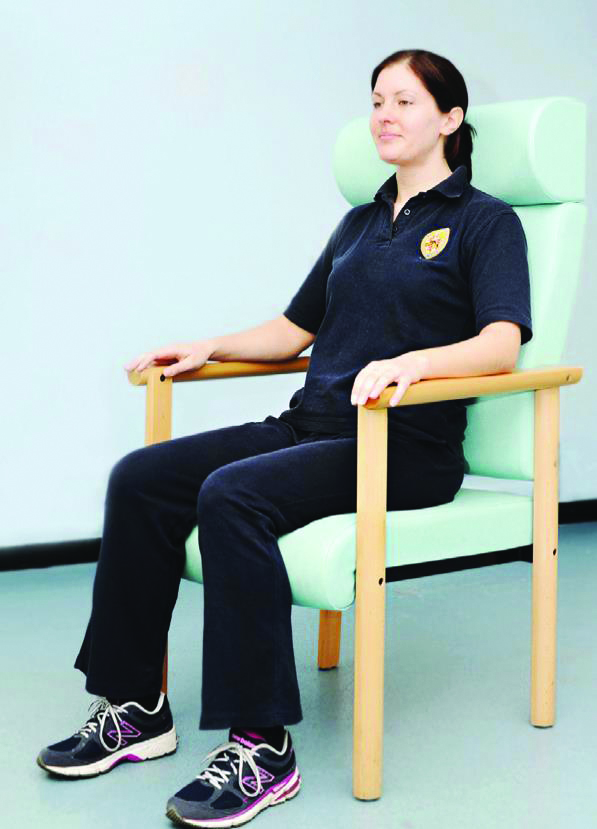 A photograph of a person sitting correctly in a chair.