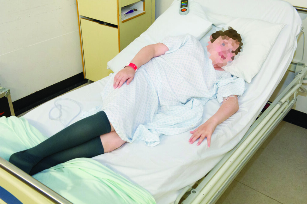 Photograph of a child lying on a hospital bed.