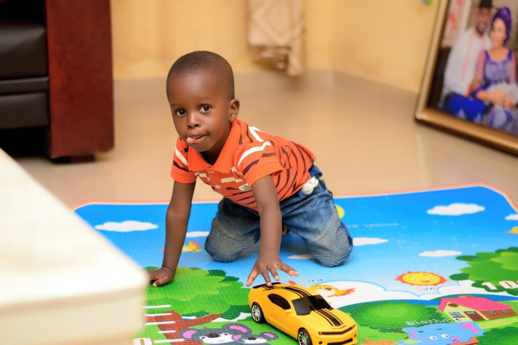 Image of child playing with toy car on a mat