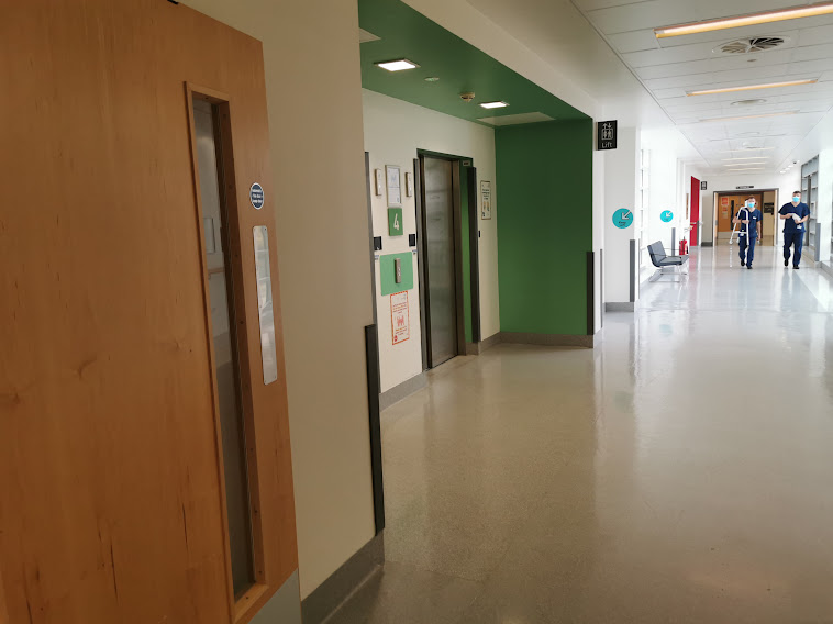 An image of the green lifts on your left down the corridor.