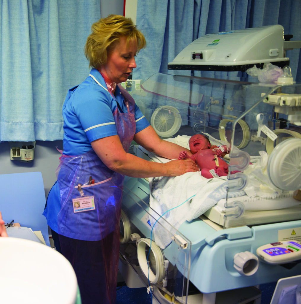 Photograph of a nurse with a new born baby.