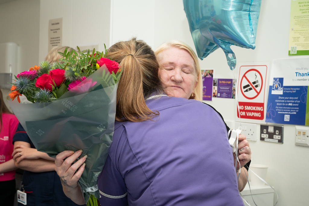 dilans mum holding flowers being hugged by critical care nurse chloe