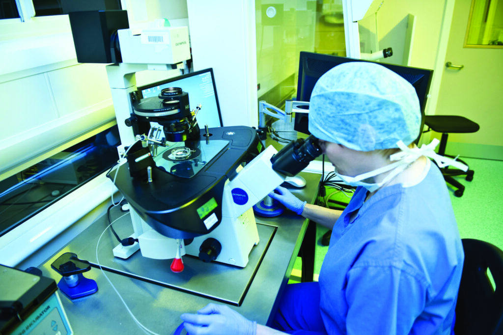 Photograph of a Sperm injection microscope and scientist.