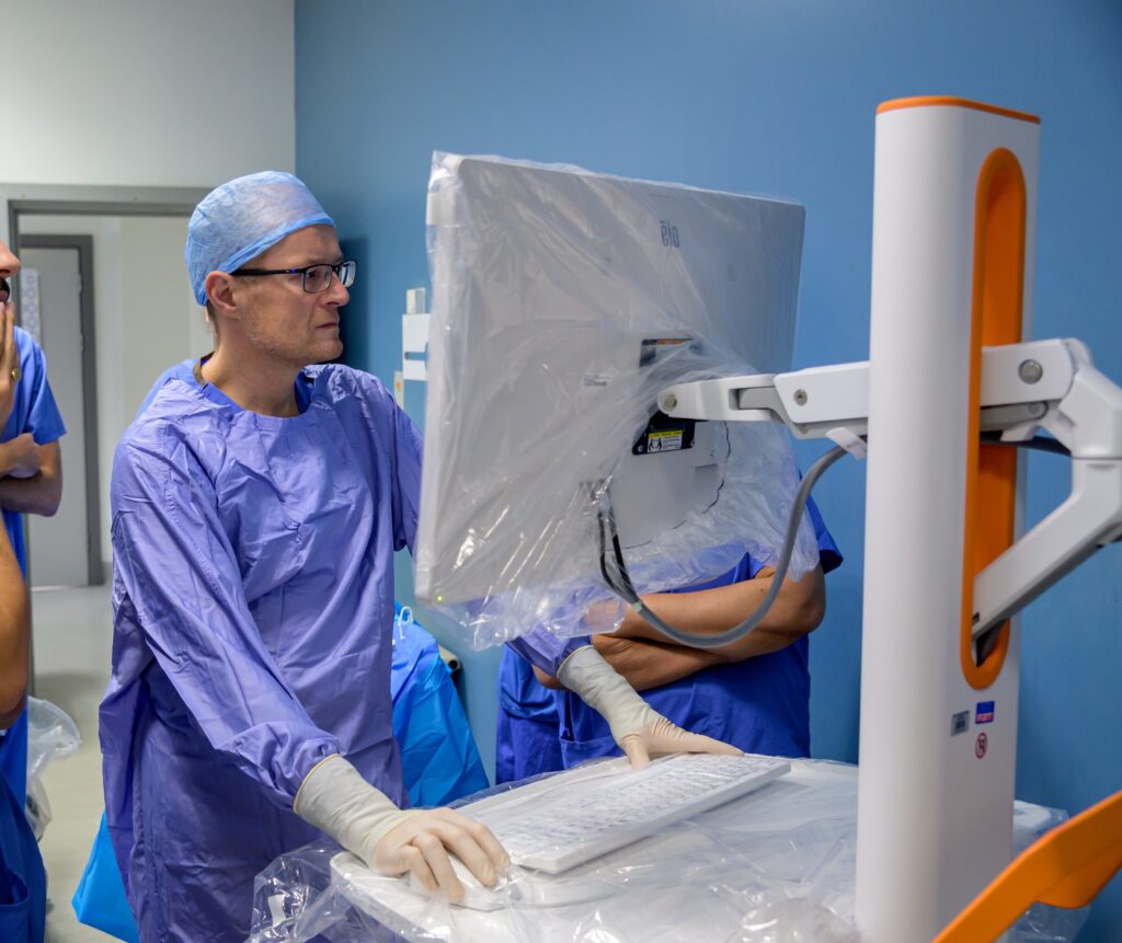 medical professional looking at digital screen and using keyboard for robotic operating machine