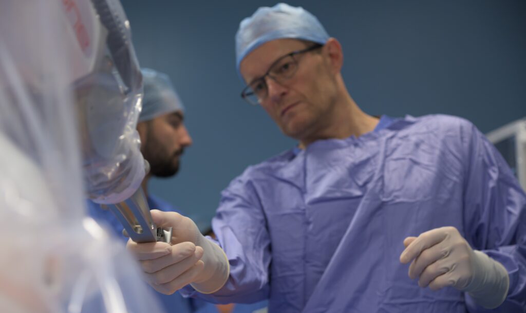 medical professional holding robotic theatre equipment