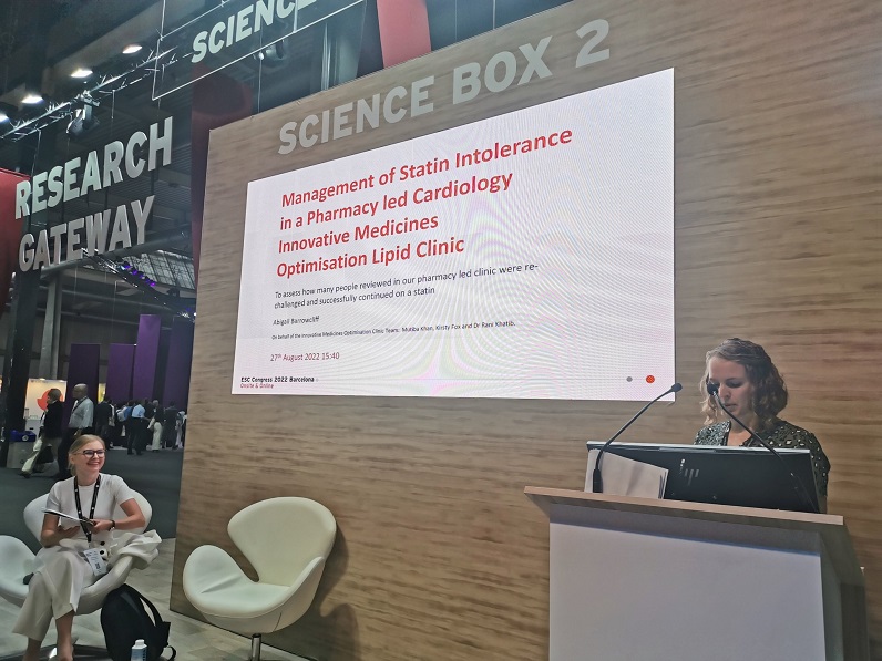 An image showing the InnoMeds Team member Abi Barrowcliff speaking at a lectern at the Science Box 2 Research Gateway. The speech is a presentation PowerPoint on Management of Statin Intolerance in Pharmacy led Cardiology Innovative Medicines Optimisation Lipid Clinic.