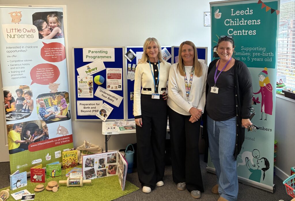 Three Leeds City Council colleagues stood next to toys and advertising stands about nurseries and children's centres.