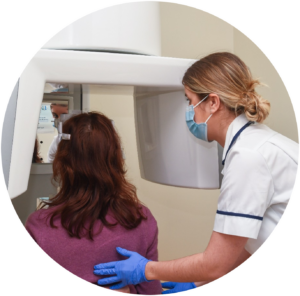 An image of a member of staff from the Dental Radiology Department assisting a patient having a dental imaging examination.