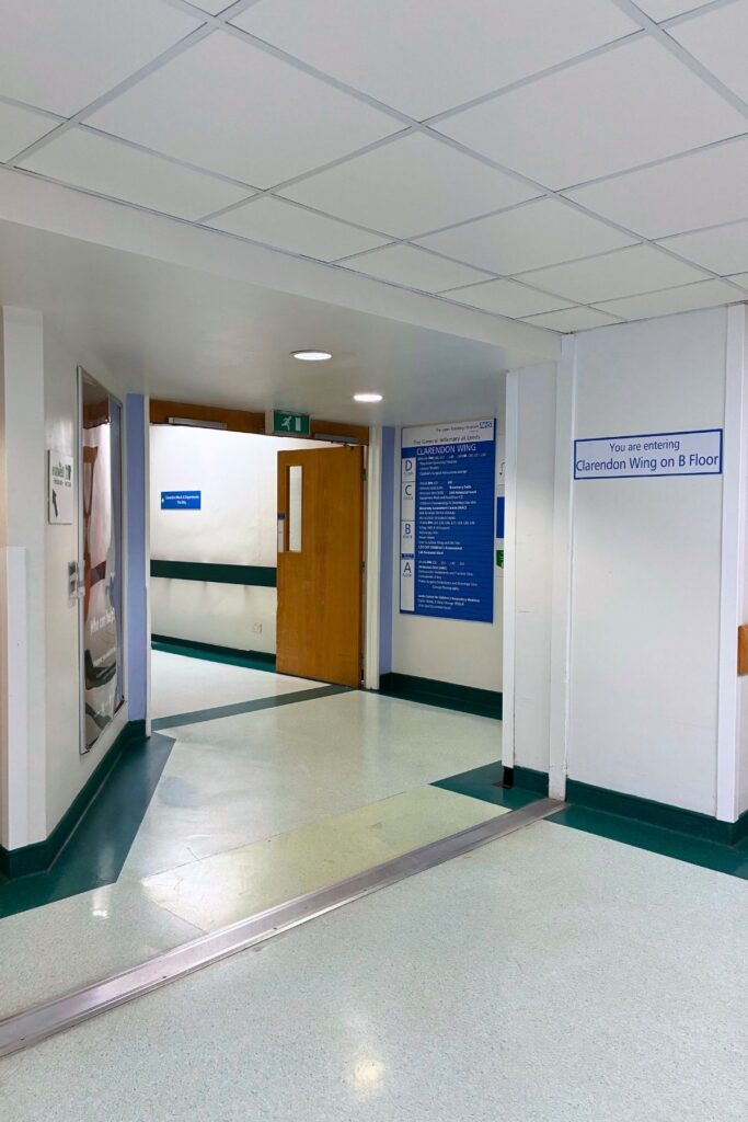 Corridor to Clarendon Wing with blue signage and wood doors