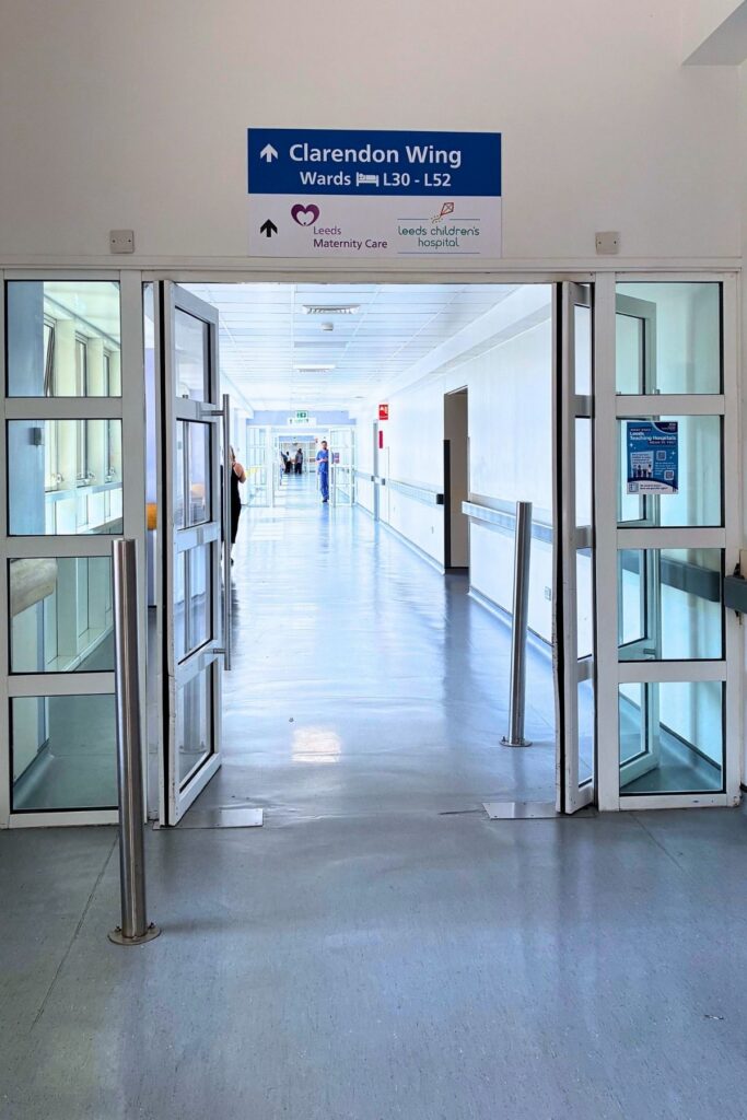 View of glass link bridge to Clarendon wing with signage for Wards L30-L52 and maternity and children's services
