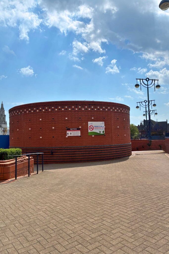 Orange brick rotunda with steps on the right and ramp on the left