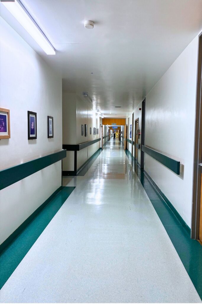 View of main corridor to Clarendon Wing with framed photos along left side