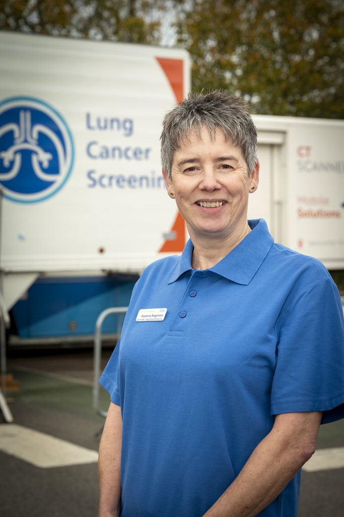 A woman in a blue shirt stood in front of a white trailer featuring the words 'lung cancer screening'