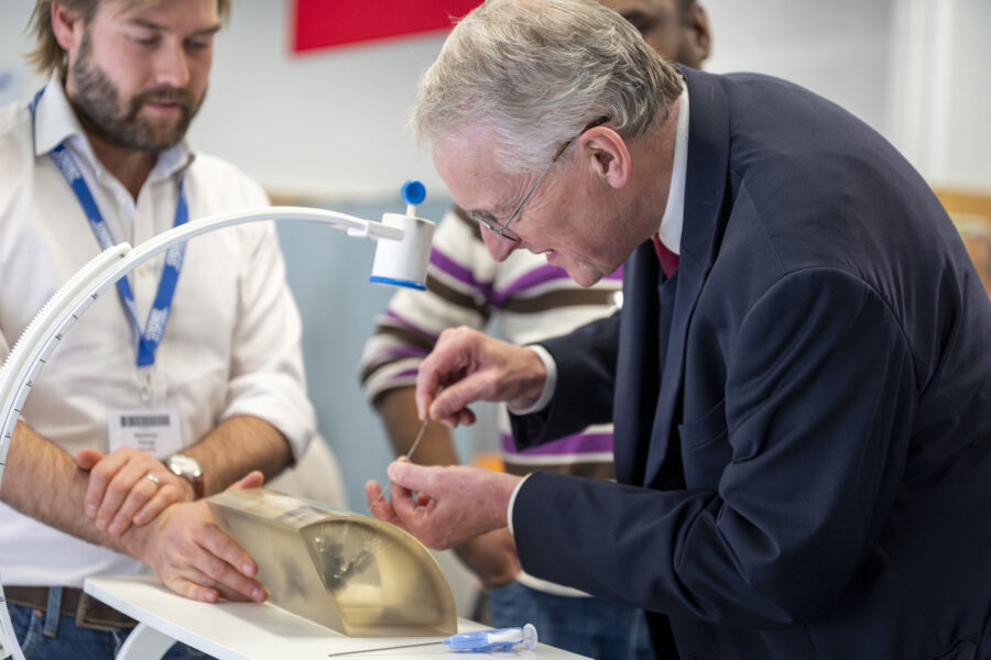 Hilary Been engages in a hands-on surgical training exercise using a simulation model during the Urology Simulation Boot Camp at Leeds Teaching Hospitals, guided by medical staff.