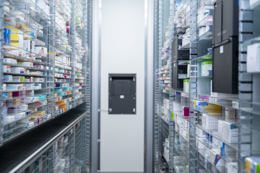 Many clear plastic shelves stacked with different packets of medicines.