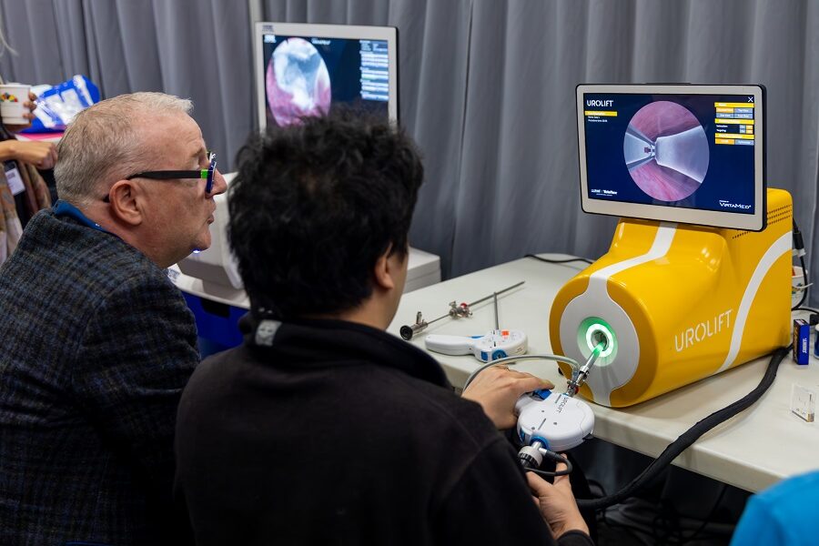 An image representing 2 males sitting down at a workstation undergoing work on using a UroLift system.