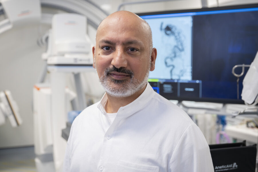A man in a white shirt looks at the camera