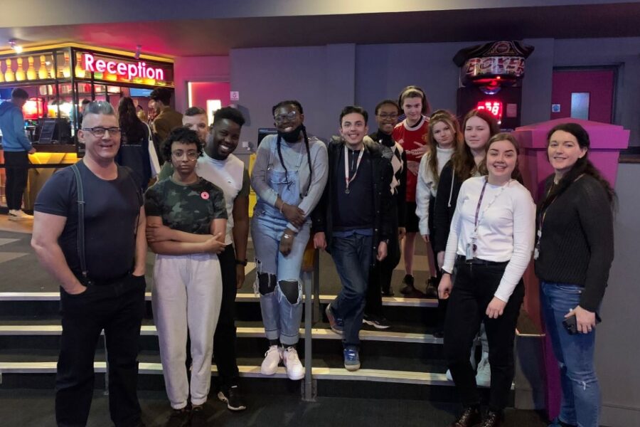 Image of young people smiling whilst in a cinema foyer